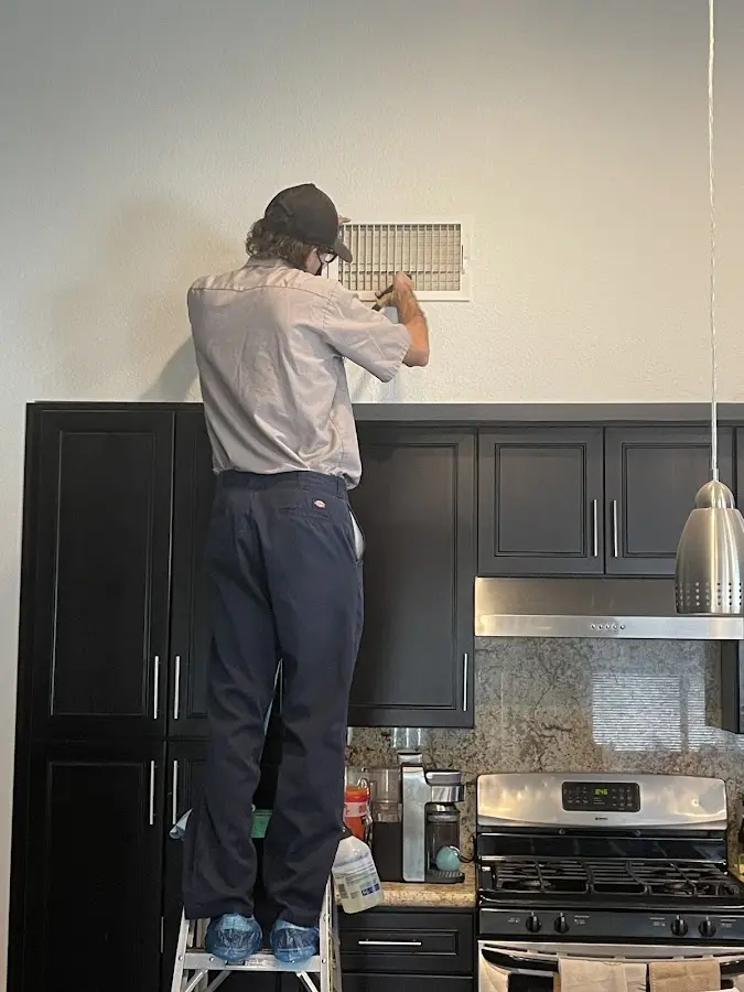 Technician inspecting an air vent during HVAC service in Leacock